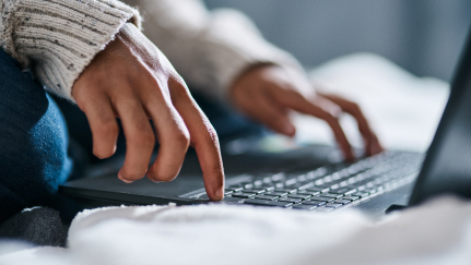 a woman's hands on a laptop keyboard