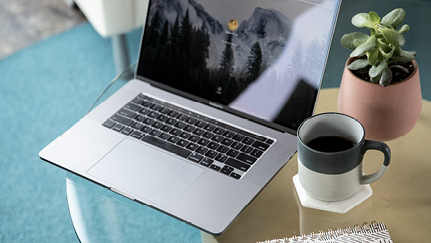 open laptop next to a cup of cofee